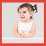 Toddler girl in a white outfit on a red background. Smiling